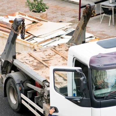 Lavoratore Edile Con Un Contenitore Metallico In Un Camion Con Detriti E Rifiuti Di Legno 1048944 21645301